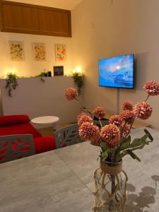 a vase with flowers on a table in a living room at Capalbio Relaxhouse in Capalbio +5 photos
