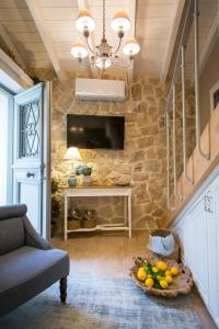 a living room with a stone wall and a chandelier at Village House Lianelia Boutique in Argyrádes