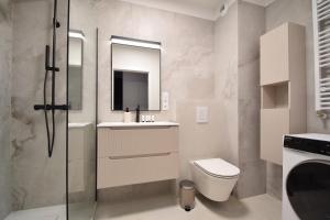 a bathroom with a toilet and a sink and a mirror at Apartament Szmaragd&Perła by LookAp - parking gratis! in Poznań +20 photos
