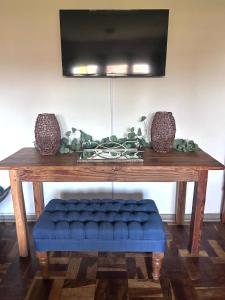 a wooden table with a blue bench under a television at Lielies Guesthouse in Parys
