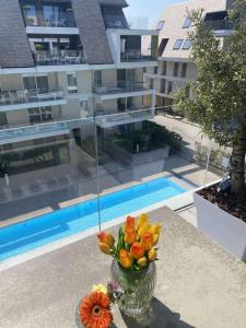 a vase of flowers on a table in front of a building at Villa Creole 0308 Luxe appartement met verwarmd zwembad Nieuwpoort Jachthaven in Nieuwpoort