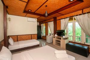 a bedroom with two beds and a television in it at Baanpufa Resort in Sai Yok