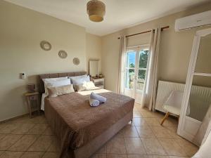 a bedroom with a bed with a teddy bear on it at Sylvia's Sweet Home in Kato Korakiana