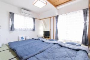 a bedroom with a large bed with a blue blanket at SY-HOTEL Kuramae 5mins 机场直达 交通便利 蔵前5分钟 in Tokyo