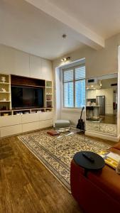 a large living room with a couch and a tv at Heart of Sydney CBD Chic One Bedroom Apartment with Pool on Bridge Street in Sydney +19 photos