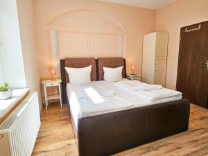 a bedroom with a large bed with white sheets at Villa Utpatel Whg 03 in Ahlbeck
