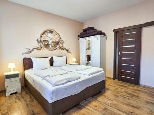 a bedroom with a large bed with a wooden floor at Villa Utpatel Whg 01 in Ahlbeck +18 photos