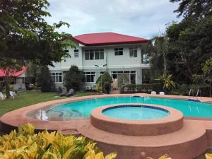 a swimming pool in front of a house at Camiguin Lanzones Resort in Mambajao