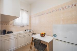 a kitchen with a table and a white refrigerator at ANESIS I in Livadi