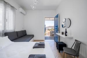 a bedroom with a bed and a couch and a mirror at ANESIS I in Livadi