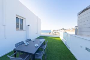 eine Terrasse mit Tisch und Stühlen sowie Strand in der Unterkunft Dúplex La Casilla in San José