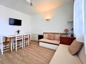 a living room with a couch and a table at Apartamento con terraza y vistas al mar en Son Bou in Son Bou