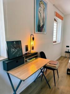 a room with a desk with a tv and a table at Coole Wohnung + Gratis Parkplatz in Schwäbisch Hall