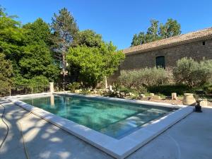 a swimming pool in front of a building at Domaine Cap Rubis in Paradou