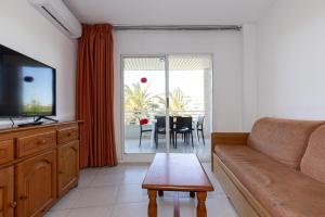 a living room with a couch and a tv and a table at Rentalmar Royal in Salou