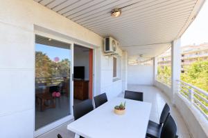 a balcony with a white table and chairs and a television at Rentalmar Royal in Salou
