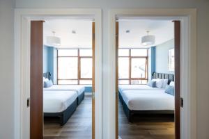 two beds in a room with two windows at Staycity Aparthotels Dublin Augustine in Dublin