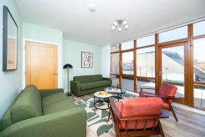 a living room with a green couch and chairs at Staycity Aparthotels Dublin Augustine in Dublin