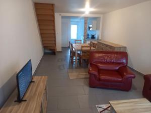 a living room with a red chair and a table at le cantalou in Rinxent