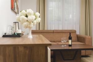 a living room with a couch and a table with a bottle and glasses at Hotel 219 Budva in Budva