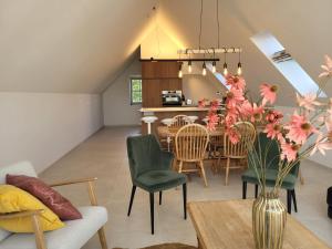 a living room and dining room with a table and chairs at Het Weiland Villa Jersey in Damme