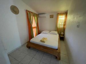 Un dormitorio pequeño con una cama y una ventana. en Casa Valencia, proche de toutes commodités, en Saint-Pierre