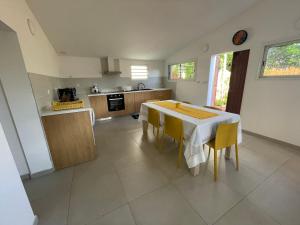 Una cocina y un comedor con mesa y sillas. en Casa Valencia, proche de toutes commodités, en Saint-Pierre