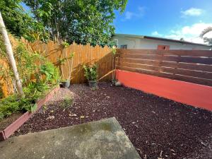 un jardín con una valla de madera y algunas plantas en Casa Valencia, proche de toutes commodités, en Saint-Pierre