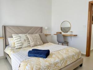 a bedroom with a bed with a blue pillow on it at Paddington House - private pool & rooftop in Flic-en-Flac +28 photos