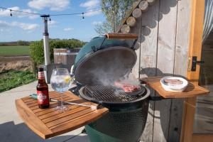 einen Grill mit einer Flasche Wein und einem Glas in der Unterkunft Deluxe Scandi Glamping Pod - Comfort in Ebberston