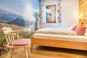 a bedroom with a bed and a chair at FEWO Immenstadt in Immenstadt im Allgäu