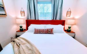 a bedroom with a large white bed with a red headboard at DwtnlParkPasslPizzaOvenlFirePitlYouTubeTVlKinglEV in Greenville