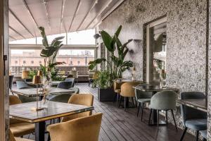 un restaurante con mesas y sillas y una gran ventana en La Griffe Hotel Roma, en Roma
