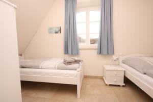 a bedroom with two beds and a window at Dat Lilli und Anni Huus in Böhl
