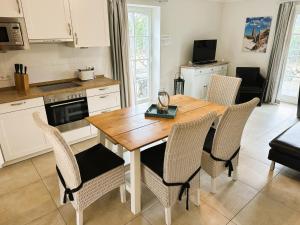 a kitchen with a wooden table and chairs at Dat Lilli und Anni Huus in Böhl +14 photos