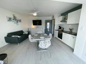 a kitchen and a living room with a table and chairs at évasion méditerranéenne - vue mer - plage in Le Barcarès