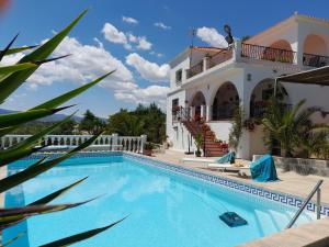 a swimming pool in front of a house at Casa Loro Loco B&B in Pedralba