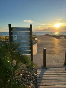 a sign on the beach with the sunset in the background at Blue Hope Duplex with sea and mountain views in Taghazout