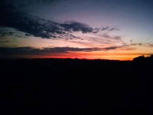 a sunset over a field with the sky at Greengardenlodge in Nosy Be