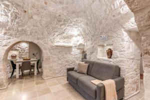 een woonkamer met een bank en een tafel bij Trullo The Cove - Le Case di Valentina in Ceglie Messapica +20 foto's