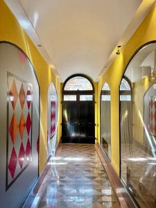 a hallway with yellow walls and a black door at 1Dest - Riva Life in Riva del Garda