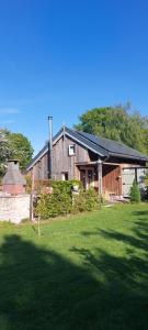a large wooden house with a large grass yard at Vakantieverblijf de Barre Hichte, Grindweg 4 Nijeberkoop in Nijeberkoop