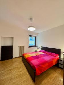 a bedroom with a large bed with a colorful blanket at 1Dest - Riva Life in Riva del Garda