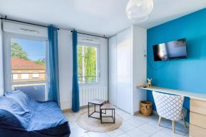 a bedroom with blue walls and a bed and a tv at L'Havre de paix - Vaulx en Velin- Proximité Lyon in Vaulx-en-Velin
