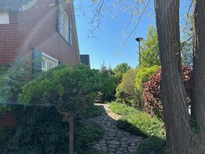 a stone walkway next to a house with a tree at Ferienhaus Frerichs 15209 in Leer