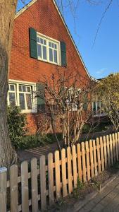 a brick house with a wooden fence in front of it at Ferienhaus Frerichs 15209 in Leer