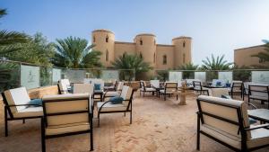 伊尔富德Palais Du Desert Hotel & Spa的大楼前带桌椅的天井