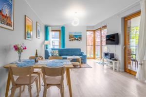 salon ze stołem i niebieską kanapą w obiekcie Luxury Apartment Bursztynowa w Gdańsku