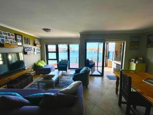 a living room with blue couches and a view of the ocean at Port Owen Marina Point in Velddrif