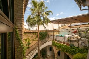 an outdoor patio with a palm tree and a swimming pool at Hotel Boutique Patio del Posadero in Córdoba